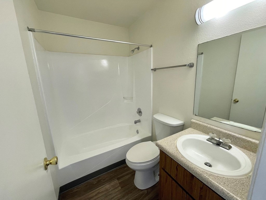 A white bathroom with a toilet, sink, and bathtub.